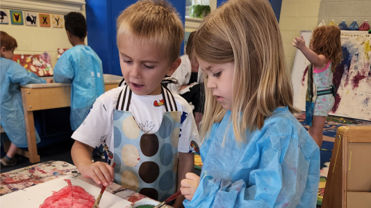 Young children painting during art class